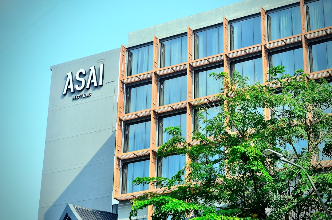 a-tall-building-with-many-windows-and-trees-in-front-of-it-ffzzzhd1gqy