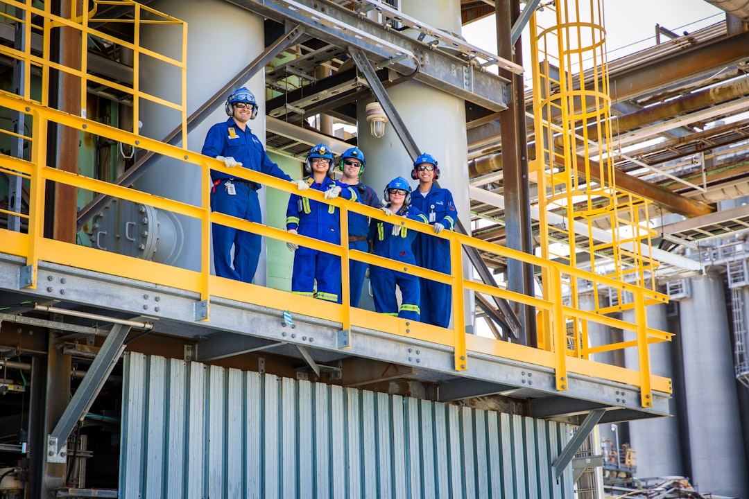 workers-stand-on-a-platform-in-an-industrial-plant-zrngypl5bhg